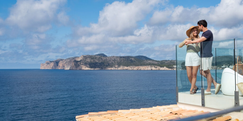 Pareja disfrutando de las vistas del mar Mediterráneo desde la terraza del hotel Fido Punta del Mar en Santa Ponsa, Mallorca