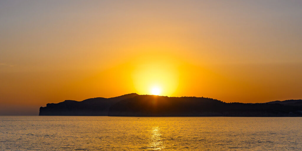 Sunset with orange sun, mountain and the sea. Santa Ponsa, Majorca, Spain, to show things to do in Santa Ponsa for couples.